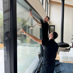 Professional installer applying solar control window film on a building glass window | Dupotop Films