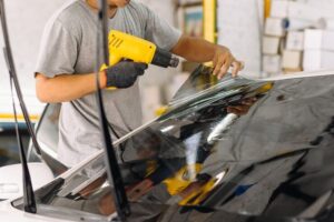Installer using heat gun at correct distance for smooth window film application